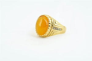 Macro d'une bague rétro dorée avec une grande pierre jaune ovale et détails en zircon