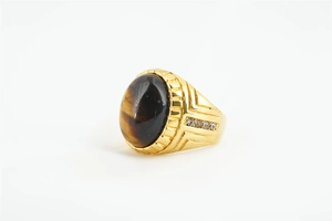 Détail d'une bague vintage en oeil de tigre avec anneau doré et accents de diamants latéraux