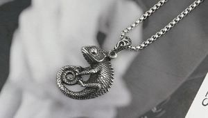 Vue détaillée d'un pendentif caméléon en argent vieilli sur une chaîne maille vénitienne