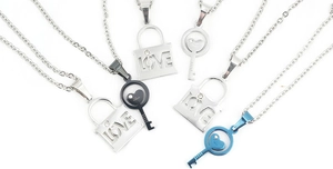 Detailed macro view of couple's lock and key pendant necklaces in silver, black, and blue