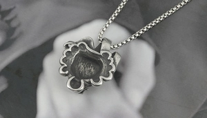 Gros plan du pendentif crâne en acier titane vintage avec finition oxydée et chaîne