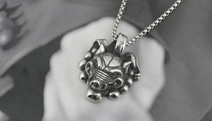 Détail du pendentif tête de sanglier en argent vintage avec gravures et chaîne box