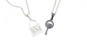 Close-up of titanium steel couple necklaces with silver lock and black key LOVE pendants