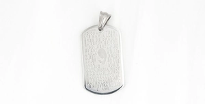 Macro detail of silver titanium steel pendant with engraved Spanish Ave Maria scripture