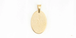 Detail of gold oval religious pendant with laser-engraved prayer text and silhouette