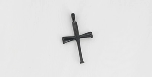 Detailed close-up of a glossy black cross pendant made of polished titanium steel material