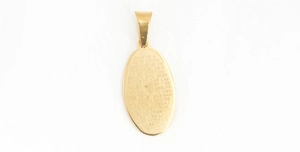 Detailed macro view of the gold oval pendant engraved with Spanish prayer text