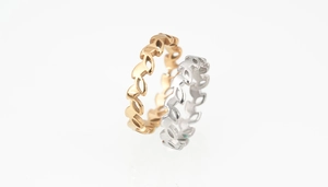 Detailed view of overlapping gold and silver rings with hollowed leaf patterns