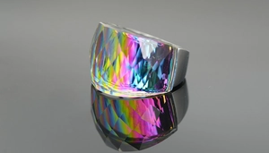 Macro shot of oversized iridescent gemstone ring with multi-faceted rainbow reflections