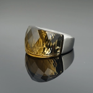 Polished silver metal ring featuring a large faceted amber gemstone in a modern wide band design