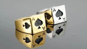 Detail of gold and silver Ace of Spades rings with high-polish mirror finish reflections
