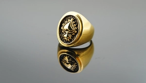Macro detail of vintage gold signet ring featuring an embossed heart motif with black texture