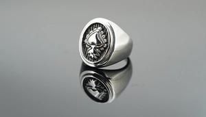 Macro shot of vintage silver steel ring with black spade emblem and oxidized finish