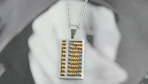 Gros plan du collier pendentif boulier bicolore montrant les perles métalliques
