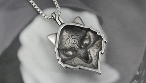 Dettaglio ravvicinato di una collana con ciondolo a testa di lupo vintage in argento