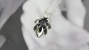 Close-up of gothic obsidian pendant with claw wings and stainless steel chain