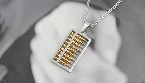 Détail d'un pendentif boulier bicolore en acier inoxydable avec des billes dorées