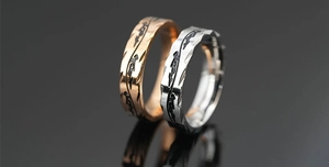 Macro detail of geometric facets and tribal flame patterns on rose gold and silver rings