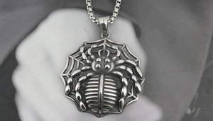 Macro shot of gothic spider pendant with spiderweb texture in vintage silver finish