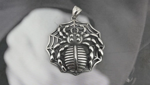Detailed macro view of vintage silver spider web pendant with engraved textures