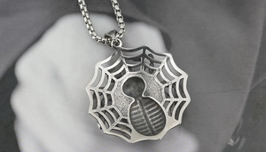 Close-up of vintage silver spider web pendant necklace with hip hop punk aesthetic
