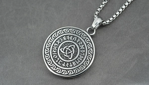 Gros plan du pendentif viking en argent mat avec nœud celtique et runes Futhark