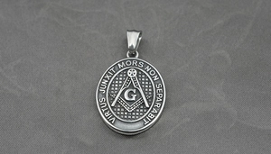 Macro shot of vintage silver Freemason pendant with compass and square emblem