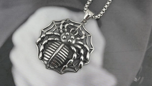 Detail of gothic spider web pendant necklace with antique silver finish and box chain