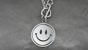 Detail of titanium steel necklace featuring a rotating smiley face pendant and OT clasp