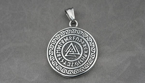 Vue macro du pendentif Viking Valknut avec runes nordiques sur fond de tissu gris