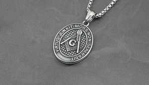 Detailed macro view of vintage titanium steel Masonic pendant with Latin engraving