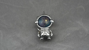 Detail of astronaut pendant with blue starry helmet and vintage silver finish