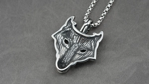 Gros plan détaillé d'un pendentif tête de loup viking en acier titane noirci avec chaîne