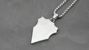 Close-up of silver titanium steel shield pendant with a brushed finish and sturdy square chain