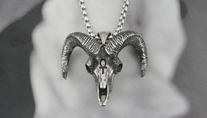 Macro detail of gothic ram skull pendant with Ankh symbol on retro silver box chain