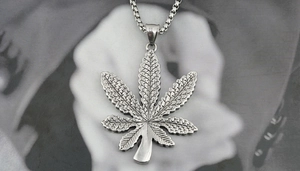 Detailed close-up of a silver maple leaf pendant with textured veins on box chain