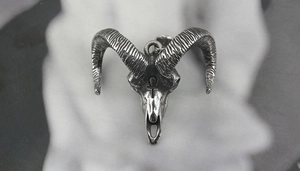 Close-up of vintage silver ram skull pendant with Ankh symbol and curved horns