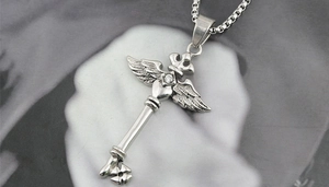 Détail du collier en acier titane argenté avec croix, couronne ailée et pendentif