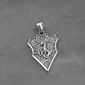 Gothic dragon shield pendant in vintage silver stainless steel on grey fabric