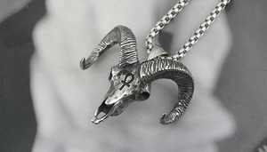 Macro detail of gothic ram skull pendant with Ankh symbol on a vintage box chain necklace