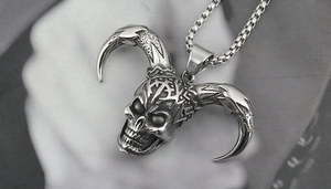 Macro shot of gothic ram skull pendant with horns on a silver box chain necklace