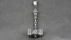 Macro detail of silver Mjolnir pendant with Valknut symbol and textured handle
