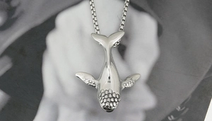 Detailed close-up of whale pendant in polished titanium steel with box chain necklace