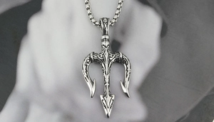 Détail macro d'un collier pendentif trident vintage avec gravures nordiques complexes