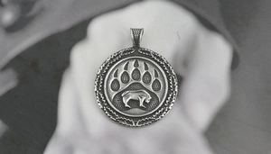 Macro shot of Viking Celtic bear paw print pendant in vintage oxidized stainless steel