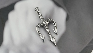 Vue macro du pendentif trident vintage avec gravures détaillées et fini argent