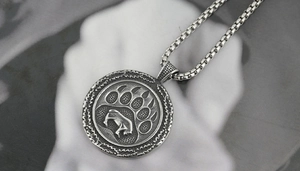 Macro shot of vintage silver bear paw pendant with intricate Nordic celtic patterns