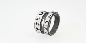 Detailed macro view of rotating stainless steel rings with engraved Buddhist mantras