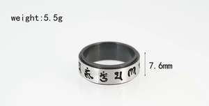 Detail of 7.6mm spinning titanium steel ring with black engraved religious symbols
