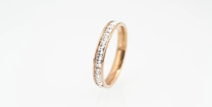 Macro shot of rose gold titanium steel ring featuring channel-set white cubic zirconia stones